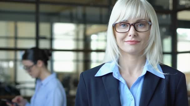 Красива блондинка, яка посміхається на камеру, надійний офіцер банку — стокове відео