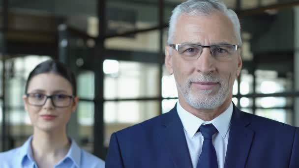 Senior man i kostym med kvinnlig assistent poserar på kamera, Fastighetsförmedling — Stockvideo