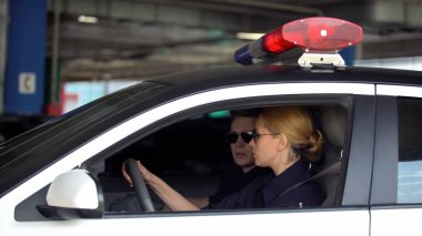 Suç mahalline polis arabası kullanan erkek ve kadın polis, şehirde devriye yasasını