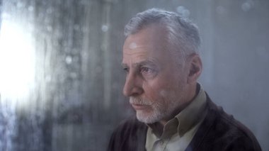 Yaşlı adam üzücü Feeling, pencere cam üzerinde yağmur damlaları, depresyon kavramı, yalnız