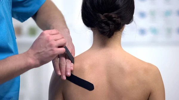 Fisioterapeuta Aplicando Fitas Forma Tensão Muscular Ombro Paciente Feminino — Fotografia de Stock