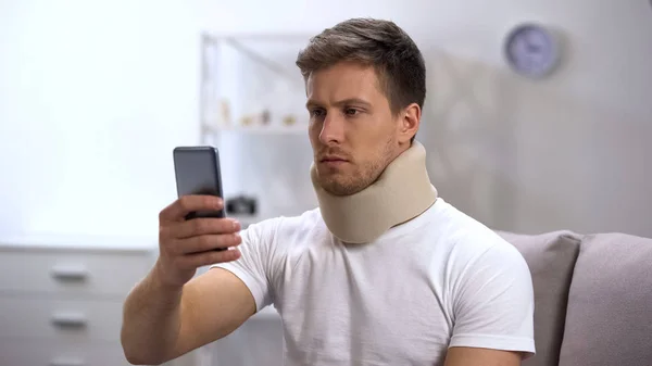 Mann Schaumstoff Halsband Liest Nachricht Auf Handy Und Spürt Schmerzen — Stockfoto