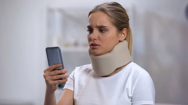 Upset Woman Foam Cervical Collar Reading Bad News Smartphone Trauma — Stock Photo, Image