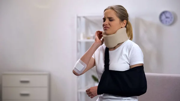 肩の痛みに苦しむ泡頸部首輪と腕のスリングで負傷した女性 — ストック写真