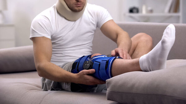 Раненый мужчина в пенопласте шейный воротник проверки неопрена коленного скобки, реабилитации
