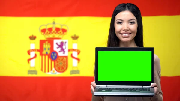 Vrouwelijke Student Holding Laptop Met Groen Scherm Spaanse Vlag Achtergrond — Stockfoto