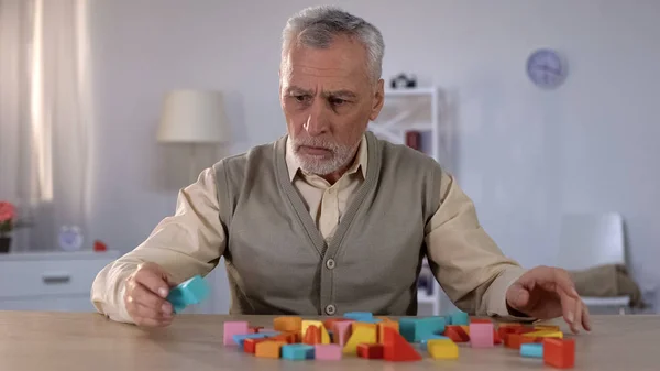 Confused Senior Man Looking Color Building Blocks Table Alzheimer Disease — Stock Photo, Image