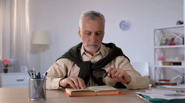 Senior Man Reading Book Con Lente Ingrandimento Attenzione Dettagli Erudizione — Foto Stock