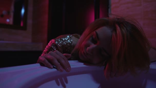 П'яна дівчина в блискучій сукні спить в нічному клубі ванна кімната, алкогольна залежність — стокове відео