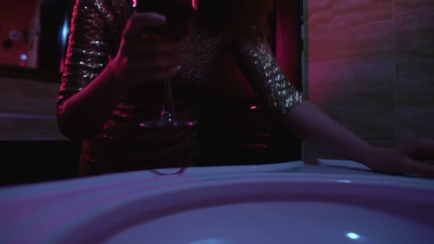 Drunk woman with glass of wine feeling bad in night club bath-room, overdrinking — Stock Video