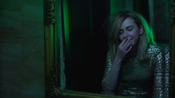 Женщина смотрит в зеркало, эйфория после нюхания кокаина в туалете ночного клуба — стоковое видео