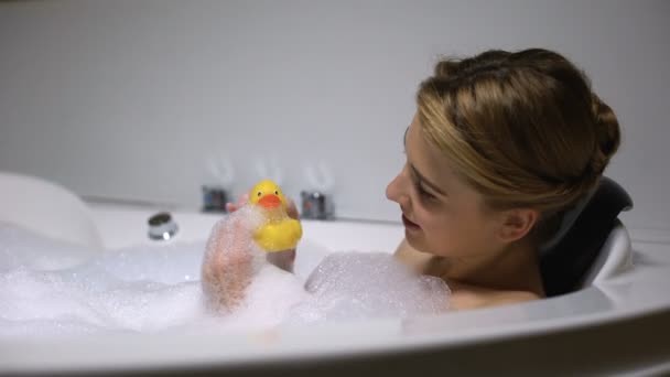 Позитивная женщина играет с резиновой уткой в ванной, детское настроение, веселится — стоковое видео