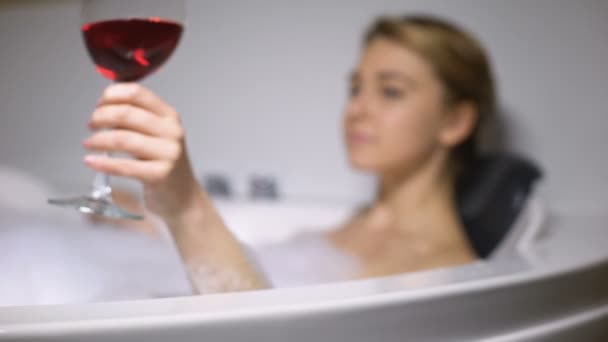 Adorabile donna che beve vino in bagno con bolle di schiuma, rilassante dopo una dura giornata — Video Stock