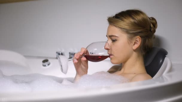 Deprimida chica acostada en el baño con burbujas de espuma beber vino, novio romper — Vídeos de Stock