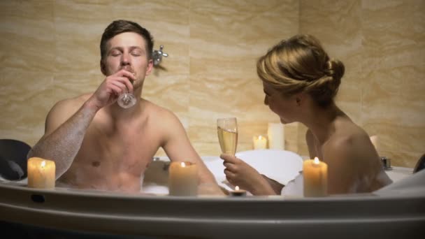 Par dricker champagne i badet, ha kul under romantisk kväll, flirta — Stockvideo