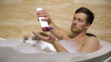 Çekici adam cilt banyo alarak içine hipoalerjenik kozmetik sürtünme, yumuşatma