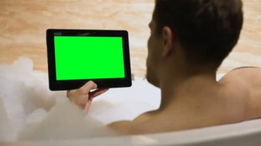 Evde küvette istirahat yeşil ekran tablet haber okuma Guy, rahatlayın