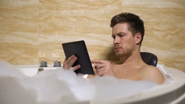 Meşgul adam banyo yapıyor ve tabletteki belgelere bakıyor, işadamı — Stok video