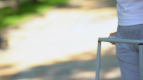 Mujer mayor que se mueve al aire libre con marco para caminar, cirugía de reemplazo de articulaciones de rodilla — Vídeo de stock
