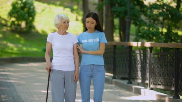 Депрессивная зрелая женщина с тростью и женщина-волонтер в саду, реабилитационный центр — стоковое видео
