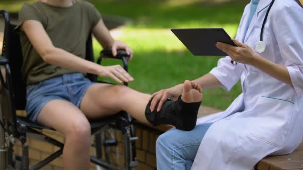 Podólogo com comprimido examinando tornozelo paciente em suporte cinta, medicina — Vídeo de Stock
