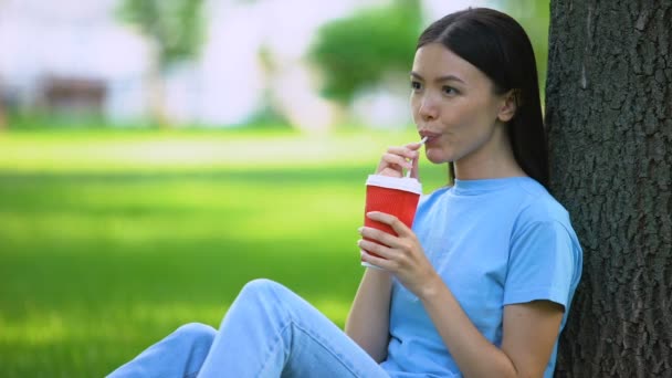 Gelukkige vrouwelijke limonade drinken door stro zittend tuin boom, verfrissing — Stockvideo