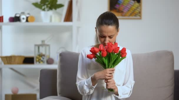 Молодая женщина держит кучу тюльпанов и чихания, сезонная аллергия, здоровье — стоковое видео