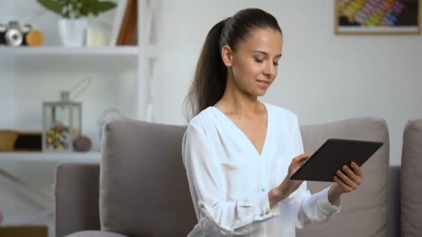 Mujer sonriente desplazándose en la tableta PC en casa, reserva de billetes de avión, tecnología — Vídeos de Stock