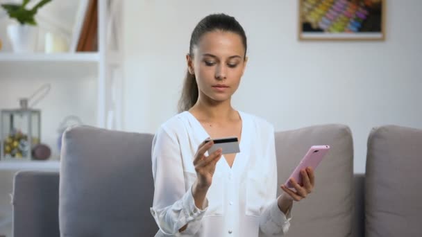 Senhora atenciosa lembrando o número do pino do cartão de crédito durante as compras no smartphone — Vídeo de Stock