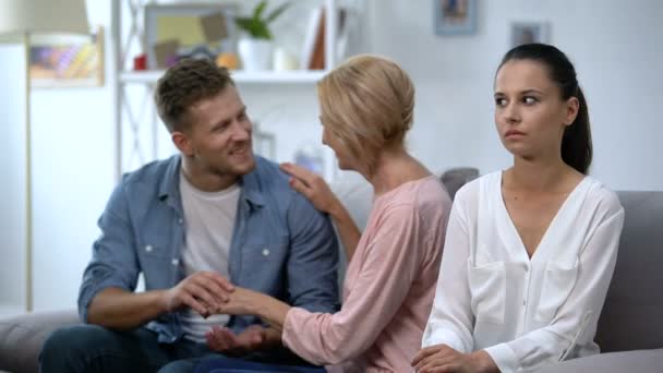 Agréable jeune homme parlant avec sa mère à la maison, tout en se disputant avec sa femme — Video