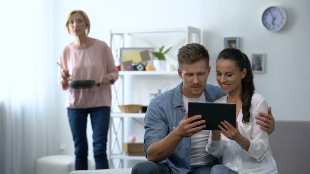 Curiosa sogra olhando jovem casal rolando no tablet PC em casa — Vídeo de Stock