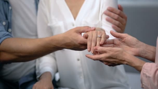 Hombre sosteniendo la mano prometida con anillo de compromiso, mostrando a la madre, familia feliz — Vídeos de Stock
