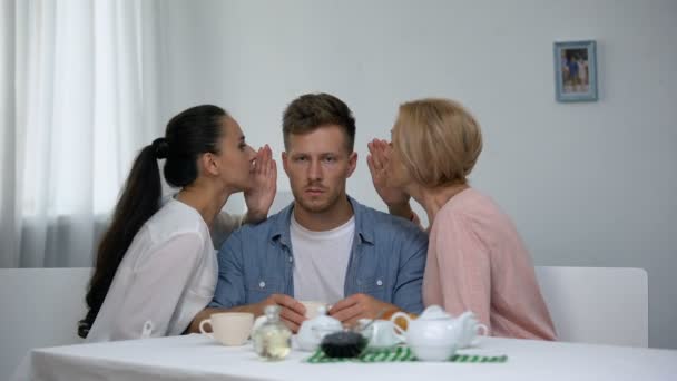 Homme irrité écoutant femme et belle-mère chuchotant sur l'oreille, problèmes — Video