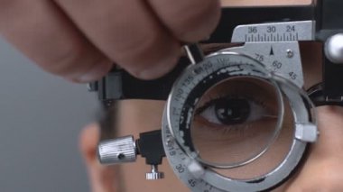 Profesyonel optometrist hasta görme kontrol etmek için phoropter içine lens koyarak