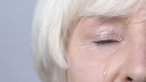 Депрессивная пожилая женщина плачет, слезы на щеке, проблемы со здоровьем, боль — стоковое видео