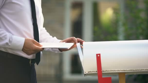 Geschäftsmann verschickt Briefe und Rechnungen und legt sie in Briefkasten in der Nähe seines Hauses — Stockvideo