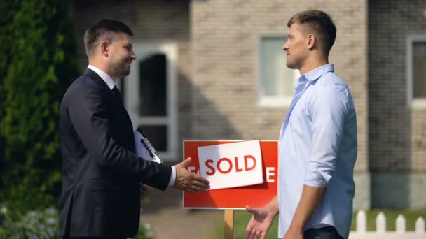 Agente inmobiliario y nuevo propietario del apartamento estrechando la mano, celebrando un buen trato — Vídeo de stock