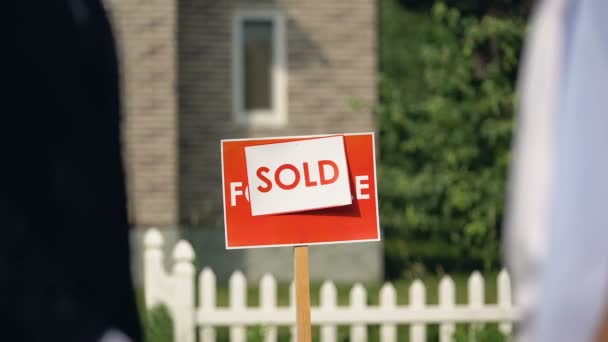 Satılan tabela, başarılı ev satın arka planda el sıkışma iki adam — Stok video