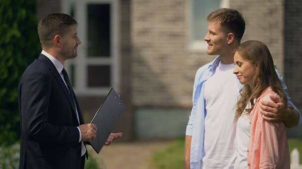 Vriendelijke makelaar presenteert luxe huisje aan familie paar, reclame — Stockvideo