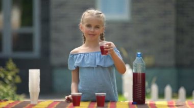 Pretty kız çilek limonata sunan, cep harçlığı kazanmak için içecek satan
