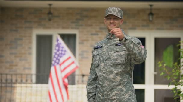 Happy military man holding keys from house, social insurance for war veterans — Stock Video