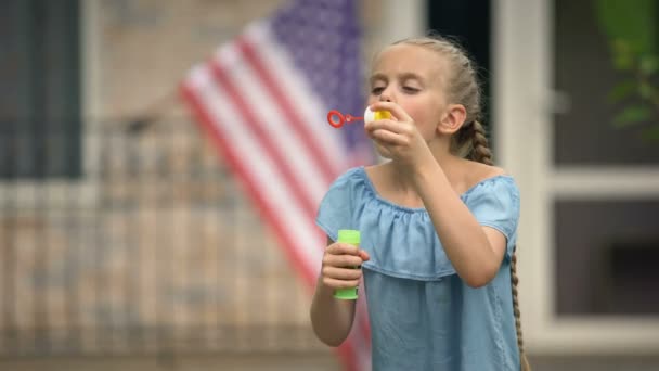 Ragazza positiva che soffia bolle di sapone, infanzia distratta e felice, tempo libero — Video Stock