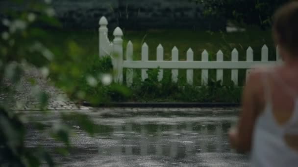Женщина быстро бежит домой из-за дождливой погоды, пытаясь спрятаться от дождя — стоковое видео