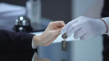 Resepsiyonist ve imza belgeleri, otel checkout anahtarı veren kadın konuk