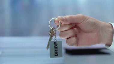 Bozuk işadamı el kamera, hukuk kötüye, suç, rüşvet anahtarlarını gösteren