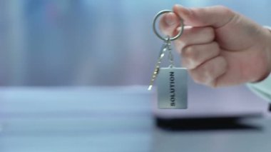 Anahtarlık elinde çözüm kelimesi kameraya gösteriliyor, fırsatı kabul etme, başlatma