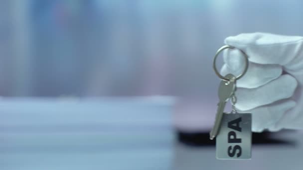 Леді беручи Spa ключі від портьє в рукавичку, відпочинок в оздоровчому готелі — стокове відео