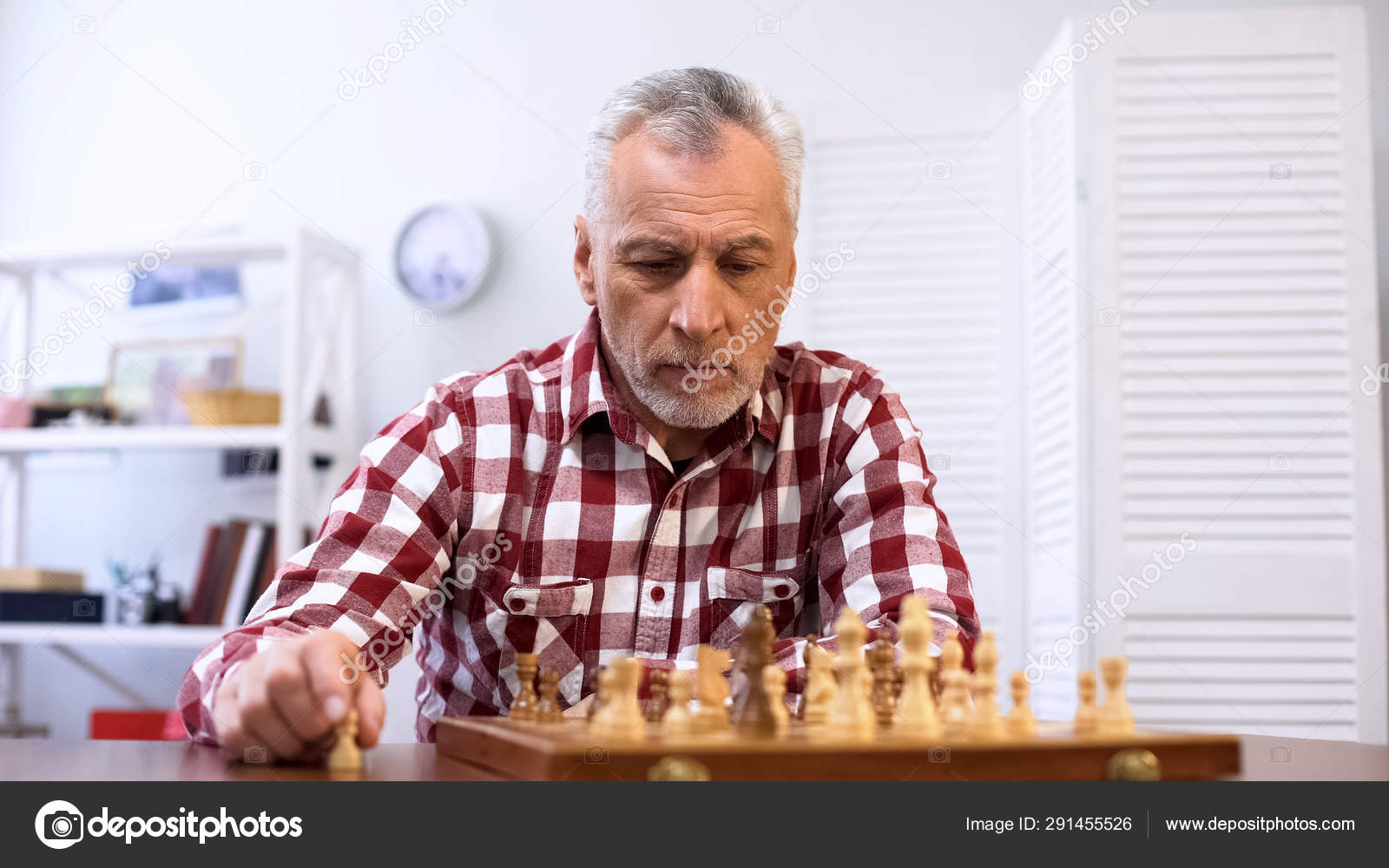 Homem jogando xadrez sozinho em casa