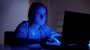 Konsantre doktor gece dizüstü bilgisayar üzerinde çalışan, hastanın tıbbi kartı doldurma