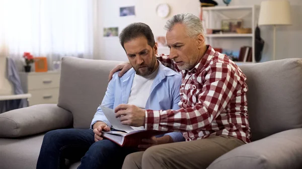 Hombres Adultos Pensativos Sosteniendo Álbum Viendo Fotos Recordando Sus Parientes — Foto de Stock